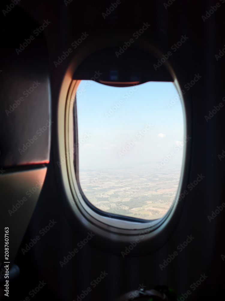 Fototapeta premium View of blue sky and clouds through an airplane window during a flight.