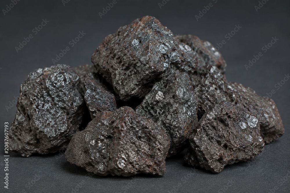 Fototapeta premium Sintered iron ore chunks with metallic sheen, industrial material close-up.