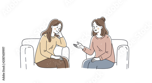 Two women sitting on a sofa talking to each other.