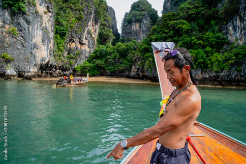 Canvastavla Thai boatman pointing finger from traditional longtail boat