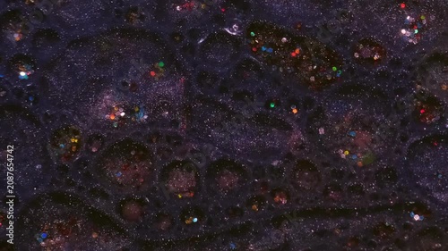 Shiny paint sequins. Oil bubbles. Defocused pink purple blue colorful bright round texture floating on abstract acrylic art background.
