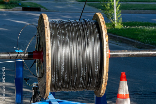 Foto Large wooden spool of new black fiber optic cable ready for installation on a street, vital for high-speed internet, data, and modern telecommunication infrastructure deployment