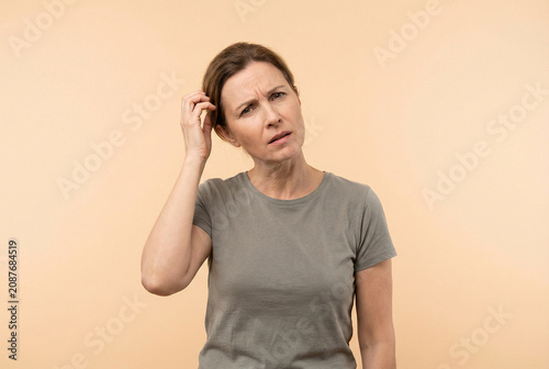 Confused Mature Woman Scratching Her Head In Studio