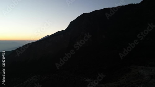 Drone footage capturing a sunrise moment at Mount Papandayan, West Java, Indonesia. Clear cloudless sky with a blue-to-orange gradient stretching across the horizon.
