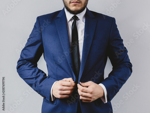 Foto Professional man adjusting his navy blue suit jacket with white shirt and black