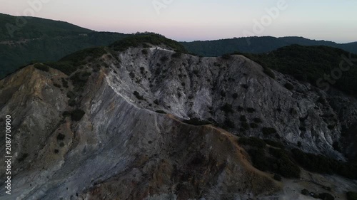 4k Drone video footage of the active crater of Mount Papandayan featuring rugged cliffs and sulfur-rich steam rising from volcanic vents in West Java, Indonesia.