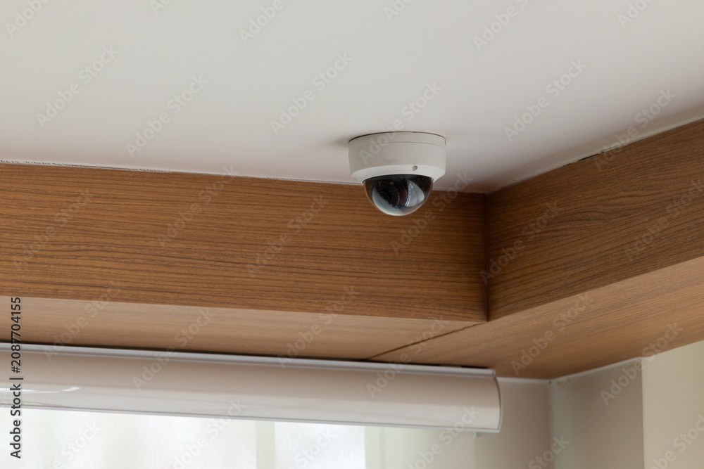Naklejka premium Ceiling-mounted security camera in modern room