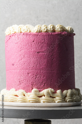 pink and cream vintage style cake on a dessert stand, trending hot pink vintage buttercream cake on a white background, process of decorating a buttercream cake