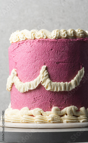 pink and cream vintage style cake on a dessert stand, trending hot pink vintage buttercream cake on a white background, process of decorating a buttercream cake