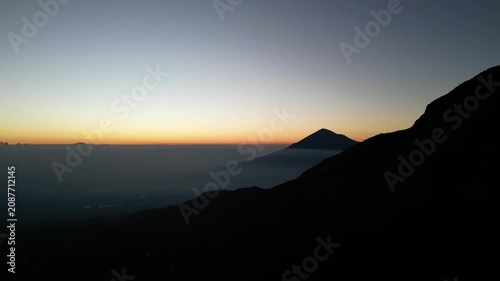 Drone footage capturing a sunrise moment at Mount Papandayan, West Java, Indonesia. Clear cloudless sky with a blue-to-orange gradient stretching across the horizon.