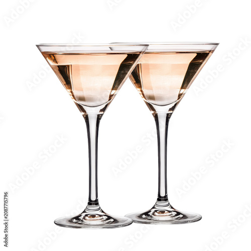 Two elegant martini glasses filled with a light pink cocktail isolated on white background