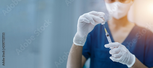 Obraz na płótnie Healthcare Professional Preparing Vaccine Injection from Medical Vial with Copy