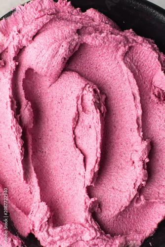 Top view of pink buttercream for decorating cake, textured american buttercream in a bowl, overhead view of grainy pink buttercream