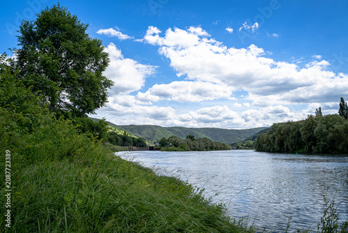 Das Licht tanzte über den Hang, während die Wolken ihre Schatten langsam über die Reben schoben. Die Mosel wirkte wie ein Spiegel, der Himmel und Landschaft zu einem einzigen Gemälde verschmelzen ließ