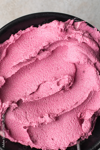 Top view of pink buttercream for decorating cake, textured american buttercream in a bowl, overhead view of grainy pink buttercream