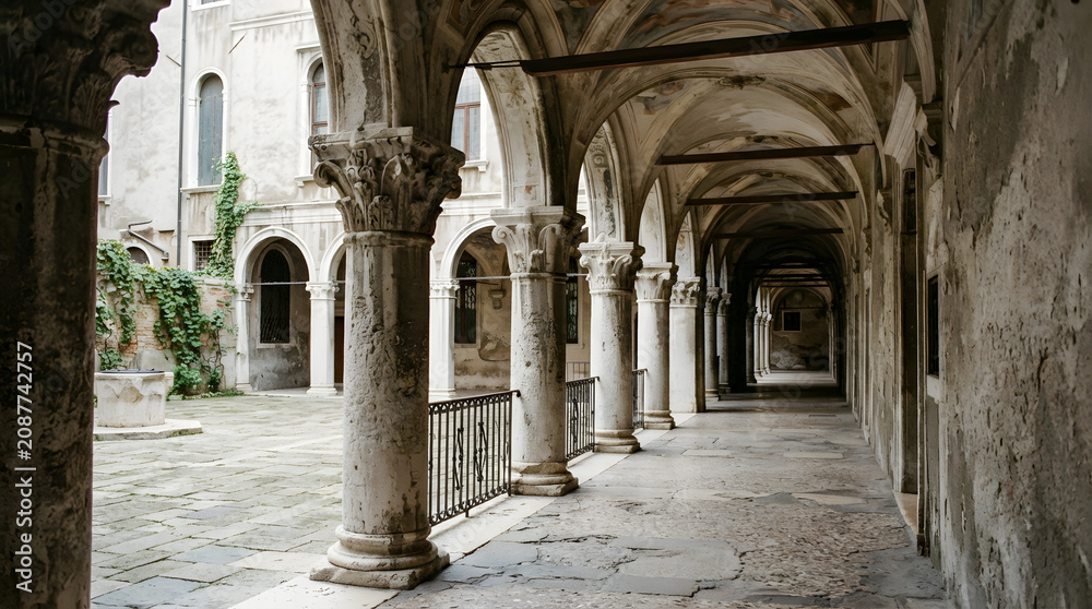 Obraz premium Ancient Architectural Stone Cloister Featuring Ornate Columns and Historic Courtyard Walkway