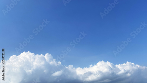 Obraz na płótnie Bright blue clear sky background featuring bottom cloud border