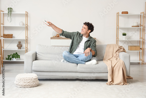 Young man sitting on sofa u...
