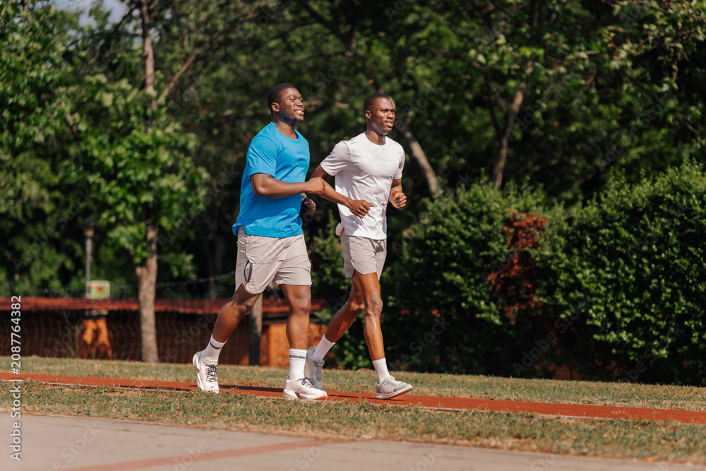 Fototapeta premium Two young men enjoying outdoor jogging on track