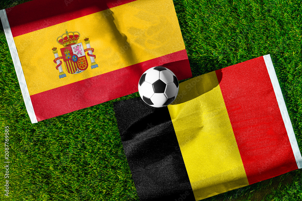 Obraz premium Spain vs Belgium, Quarterfinals, national flags before international football match, football on green grass with stadium in the background, SoFi Stadium, Inglewood, United States, July 10, 2026.
