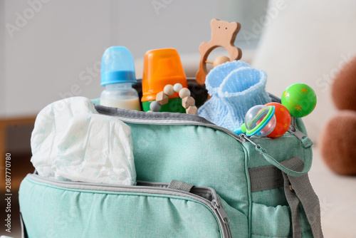 Tableau sur toile Baby bag with accessories in living room, closeup