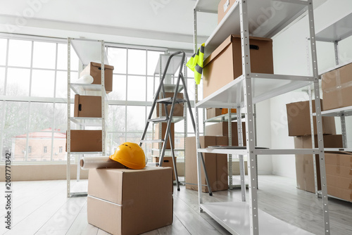 Canvastavla Shelf units with cardboard boxes and stepladder in warehouse