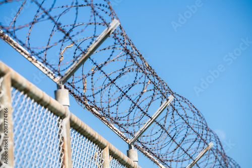 Принти на полотні Barbed wire fence symbolizing border control, geopolitical tensions, and restricted freedoms in modern society