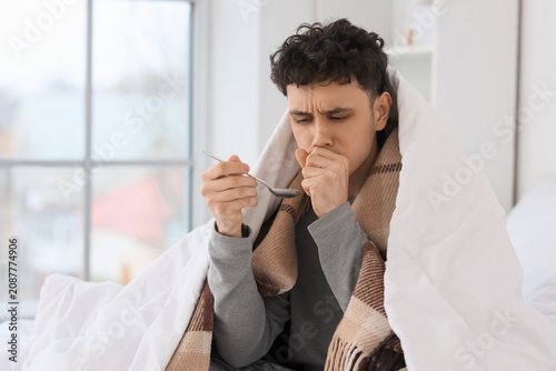 Ill young man with spoon of...