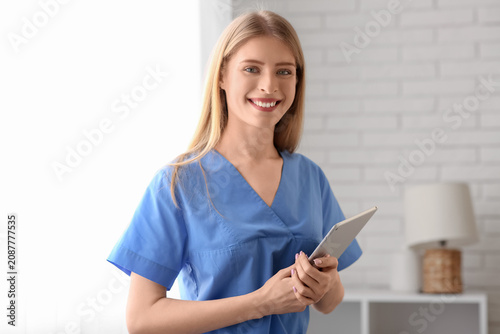 Female medical intern with tablet at home