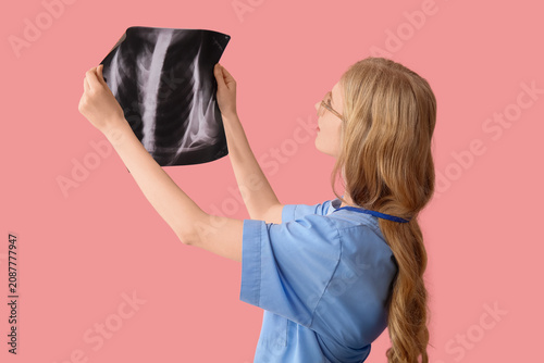 Female medical assistant on pink background