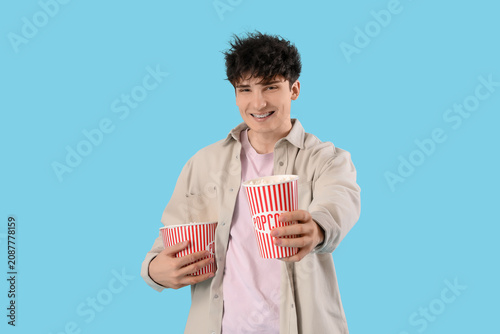 Young man giving popcorn on...
