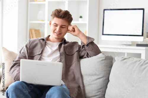 Young man using laptop on s...