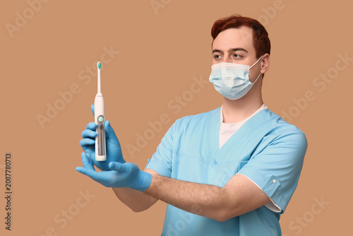 Male dentist in mask with e...