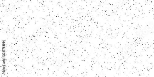 A field of countless tiny grey specks scattered randomly across a stark white background creates an abstract pattern of light and shadow, suggesting a subtle texture or a distant, blurred landscape.