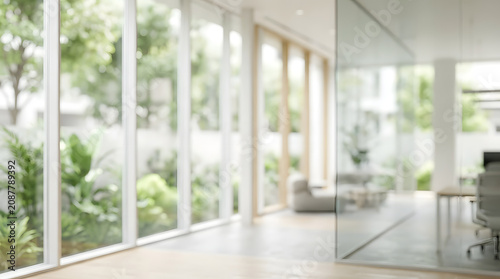 Modern bright minimalist office interior or living room with large glass doors overlooking a green garden, empty space background with copy space.