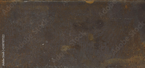 A close-up of a dark, rusty metal surface, portraying a weathered industrial background with subtle textural variations.