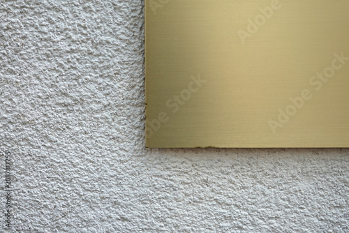 Bild auf Leinwand Plaque d'acier brossé or posé sur un mur en crépi