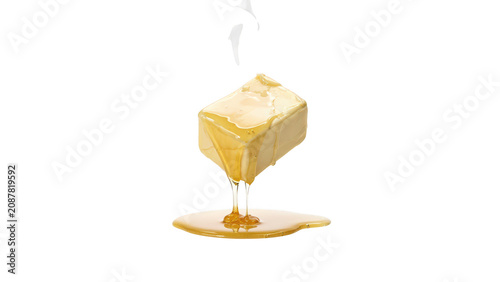 A single square block of yellow butter melting and dripping onto a flat surface, captured against a solid black background, for contrast
