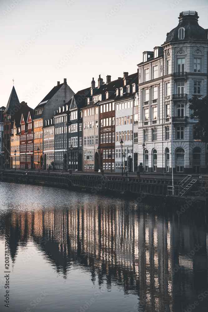 Fototapeta premium detailed view of nyhavn canal at dusk with reflections of the buildings and the boats in the water
