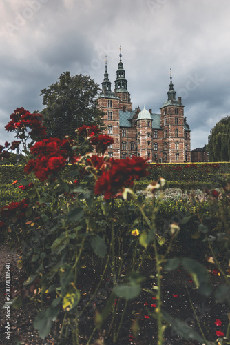 rosenborg slot in copenhagen on a cloudy day and roses in the foreground
