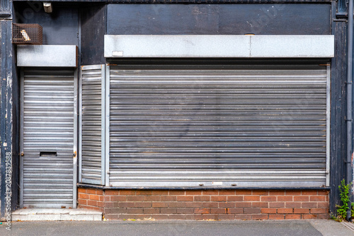 Closed down and shuttered shop with removed company name