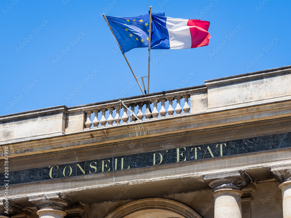 Obraz premium Paris, France - June 17, 2026: Low angle view of the sign on the portico at the entrance of the Council of State, decked with french and European Union flags, located in the Palais Royal.