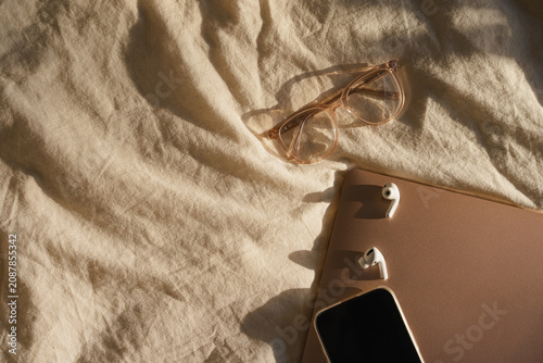 Cozy Tech Essentials on Beige Fabric with Glasses, Laptop and Phone