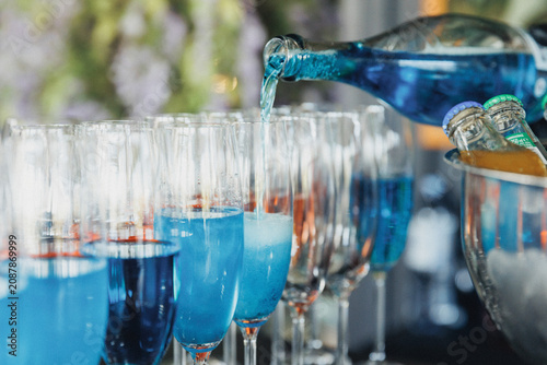 Fotografía Blue liquid pours into clear glasses