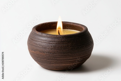 Burning Candle in Glass Bowl with Glowing Flame on Black Dark Background for Candlelight Decoration and Holiday Celebration