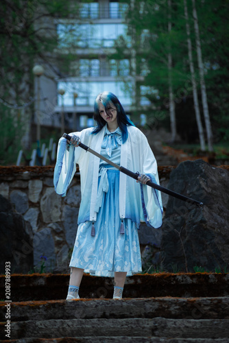 Fantasy woman in blue dress holding a staff on stone stairs