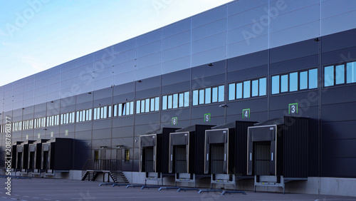 Cuadro en lienzo Modern warehouse building features a long exterior facade with numerous numbered