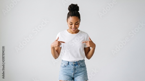 Young woman in white t-shirt pointing at herself with t shirt pointing portrait confident expression lifestyle