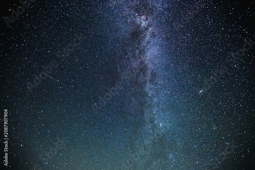 Принти на полотні Under a dark sky, countless stars twinkle brightly, creating a stunning view of the Milky Way