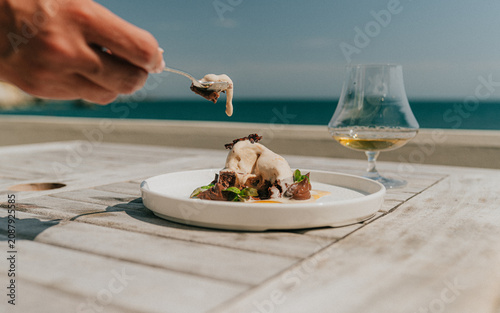 Fotografie Close-up of dessert plating with a glass of liquor on wooden table